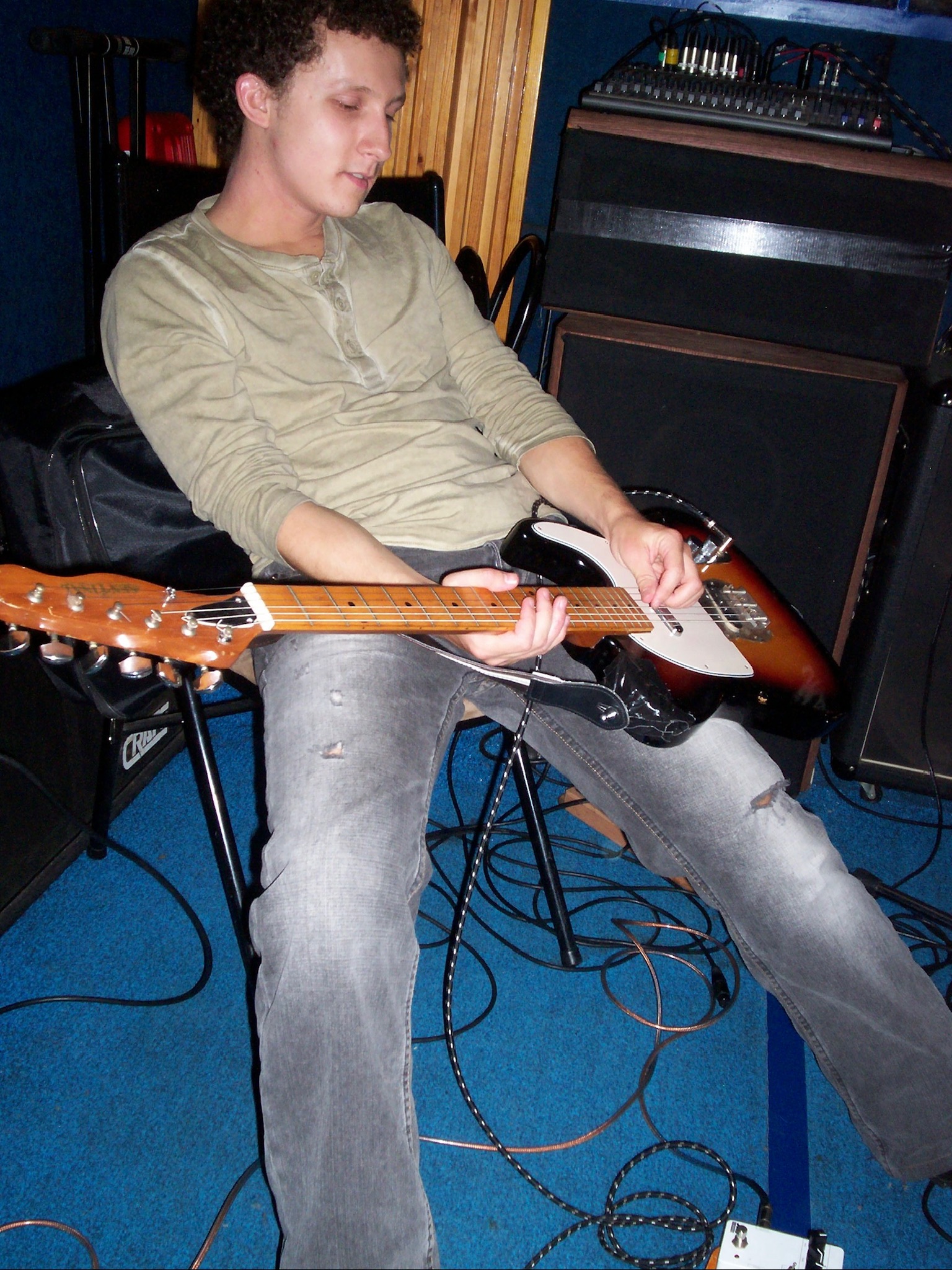 guitarist seated in a rehearsal room