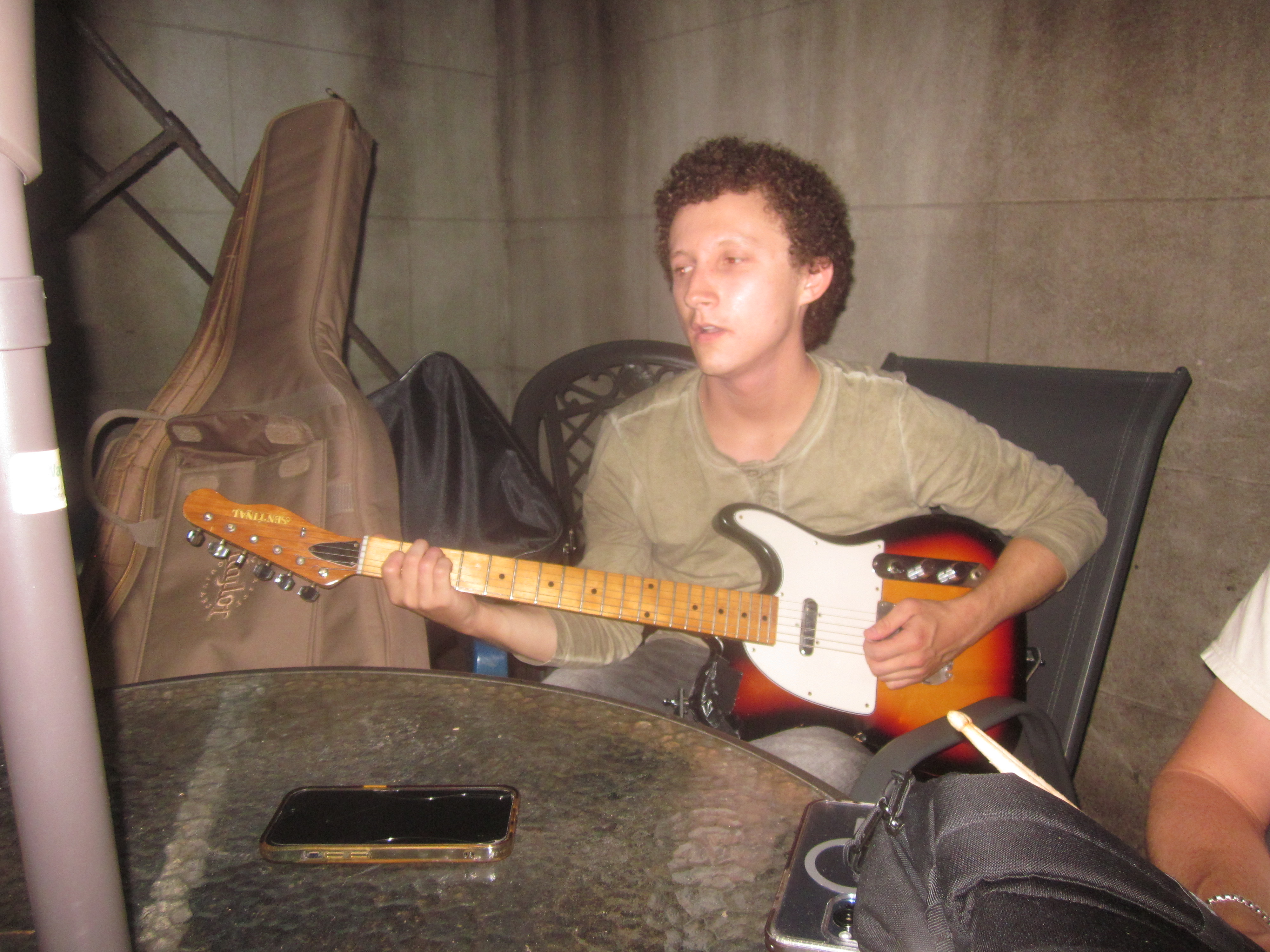 guitarist seated in a rehearsal room